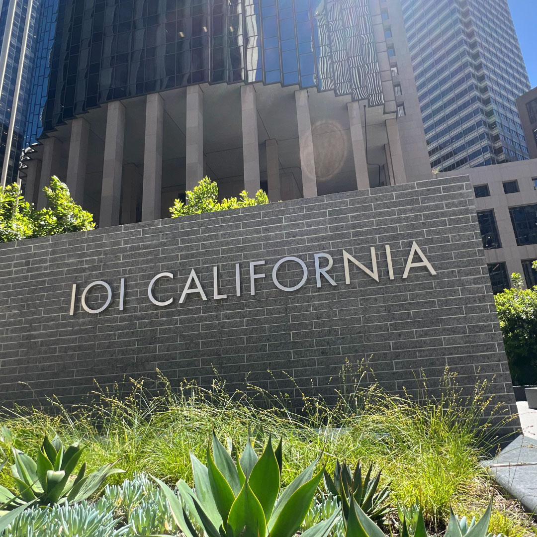 Outdoor monument sign showing 101 California name surrounded by native plants