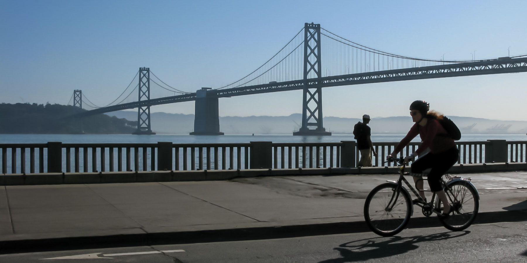 Bicycle commuter with Bay Bridge in the background