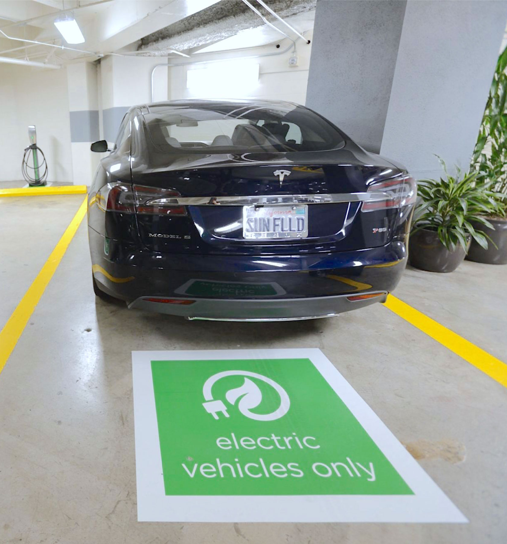 An electric vehicle charging at a designated space in the garage